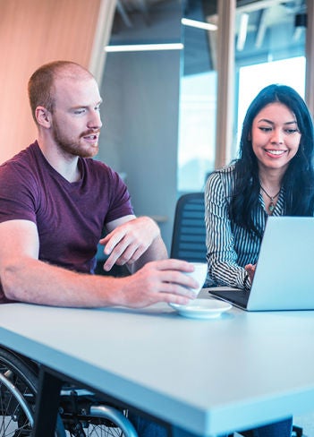 Uma mulher e um homem na frente de um computador