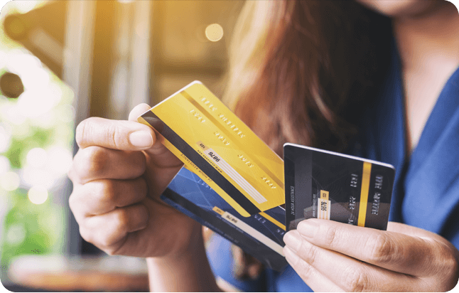 Uma mulher segurando cartões de crédito
